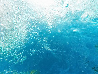 Kabarcıklar ve güneş ışığıyla sualtı görüntüsü.