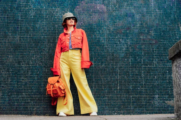 선글라스를 양동이 모자를 녹색의 배경에 도시의 길거리 블로거 선택적 집중입니다 — 스톡 사진