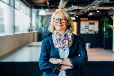 Gülümseyen 50 'lerin şık, kendine güvenen iş kadını, orta yaşlı şirket CEO' su, modern ofiste kıdemli bayan profesyonel koç takım lideri portresi. Kadın lider.