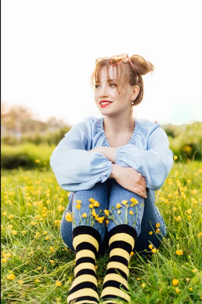 블라우스와 청바지를 노란색 양말을 여자가 초원의 잔디에 애니메이션 스타일 꽃피는 — 스톡 사진