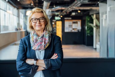 Gülümseyen 50 'lerin şık, kendine güvenen iş kadını, orta yaşlı şirket CEO' su, modern ofiste kıdemli bayan profesyonel koç takım lideri portresi. Kadın lider..