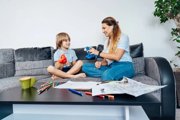 リビングルームで一緒におもちゃでロールゲームをプレイ幸せな母親と息子 子供の精神療法のプロセス ゲームやダイアログの勉強 幸せな家族だ 若い母親と息子は家で活動しています — ストック写真