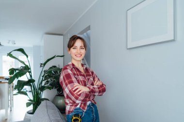 Happy 'nin portresi, evindeki duvara bir resim astıktan sonra kendiyle gurur duyuyordu. Oda temizliği işi. Kendini tamir ediyor. Ev dekorasyonu. DIY kavramı.