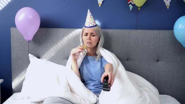 Sad Woman Pajamas Party Cap Drinks Champagne Watches Wrapped Blanket — Vídeos de Stock