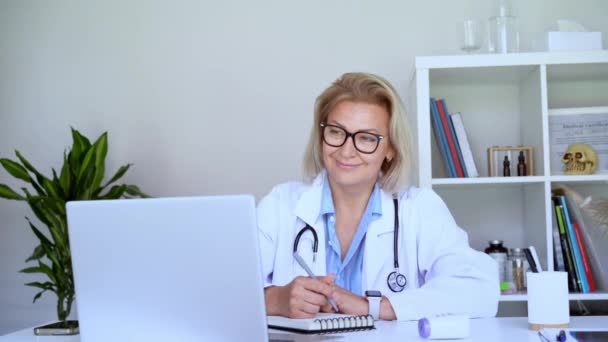 병원에서 환자와 노트북을 코트에 성공적인 성숙한 코카서스 Gp는 온라인 환자를 — 비디오