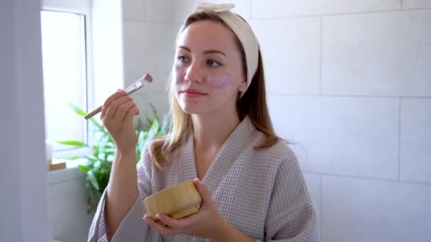 Young Woman Bathrobe Looking Mirror Applying Natural Cosmetic Clay Mask — Vídeo de Stock