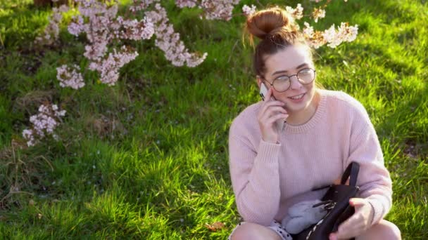 Νεαρό Καυκάσιο Hipster Κορίτσι Γυαλιά Και Ελαφρά Ρούχα Κάθεται Στο — Αρχείο Βίντεο