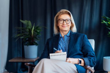 Gülümseyen 50 'lerin şık, kendine güvenen iş kadını, orta yaşlı şirket CEO' su, modern ofiste kıdemli bayan profesyonel koç takım lideri portresi. Kadın lider..