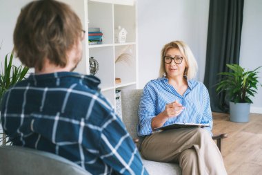 Profesyonel psikoterapi. Kadın psikolog, erkek hasta ile ruh sağlığı kliniğinde seans yapıyor. Psikolojik yardım servisi. Depresyon tedavisi.