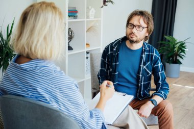Ruh sağlığı kliniğinde psikoterapi gören depresyondaki bir erkek hasta. Duygusal sorunları olan bir adam profesyonel terapiste danışıyor ben de rahat bir ofise. Psikolojik yardım hizmeti