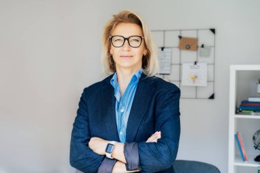 Gülümseyen 50 'lerin şık, kendine güvenen iş kadını, orta yaşlı şirket CEO' su, modern ofiste kıdemli bayan profesyonel koç takım lideri portresi. Kadın lider..