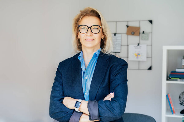 Portrait of smiling 50s stylish, confident mature businesswoman, middle aged company ceo director, experienced senior female professional, business coach team leader in modern office. Female leader.