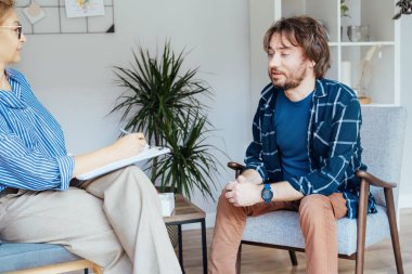 Ruh sağlığı kliniğinde psikoterapi gören depresyondaki bir erkek hasta. Duygusal sorunları olan bir adam profesyonel terapiste danışıyor ben de rahat bir ofise. Psikolojik yardım hizmeti