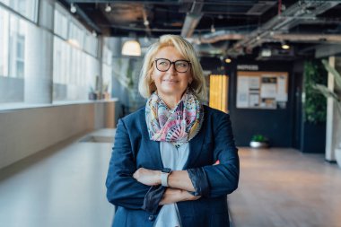 Gülümseyen 50 'lerin şık, kendine güvenen iş kadını, orta yaşlı şirket CEO' su, modern ofiste kıdemli bayan profesyonel koç takım lideri portresi. Kadın lider.