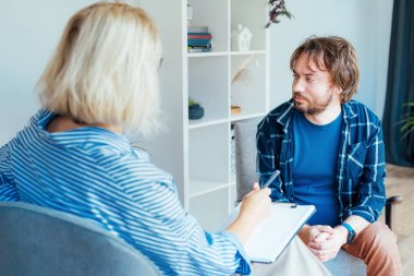 Ruh sağlığı kliniğinde psikoterapi gören depresyondaki bir erkek hasta. Duygusal sorunları olan bir adam profesyonel terapiste danışıyor ben de rahat bir ofise. Psikolojik yardım hizmeti