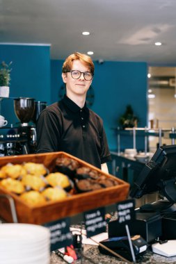 Genç garson, kafede müşteriye servis yapıyor. POS terminalinde çalışan bir adam. Kasiyer, kahveci ödeme makbuzunu kontrol ediyor. Konukseverlik, sunucu ve kahve dükkanında fişi hazırlama