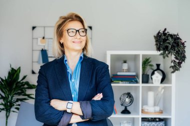 Gülümseyen 50 'lerin şık, kendine güvenen iş kadını, orta yaşlı şirket CEO' su, modern ofiste kıdemli bayan profesyonel koç takım lideri portresi. Kadın lider..