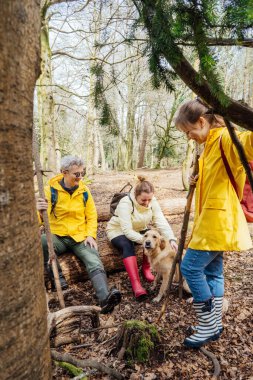 Bir grup arkadaş ormanda sırt çantalarıyla dinleniyor. Macera dolu bir hayat tarzı, tatilde doğa yürüyüşü seyahati. Turizm, yürüyüş ve arkadaşlık konsepti. Açık hava aktiviteleri