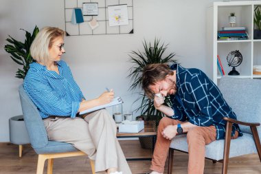 Ruh sağlığı kliniğinde psikoterapi gören depresyondaki bir erkek hasta. Duygusal sorunları olan bir adam profesyonel terapiste danışıyor ben de rahat bir ofise. Psikolojik yardım hizmeti