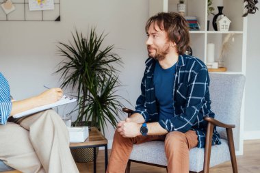 Ruh sağlığı kliniğinde psikoterapi gören depresyondaki bir erkek hasta. Duygusal sorunları olan bir adam profesyonel terapiste danışıyor ben de rahat bir ofise. Psikolojik yardım hizmeti