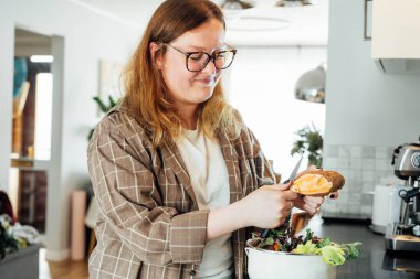 Mutfak atıklarını gübrelemek, evde geri dönüşüm yapmak. Sebzeleri kesilen artıkları çöpe atan kadın mutfak masasındaki gübre kutusu. Çevresel sorumluluk, ekoloji. Seçici odak