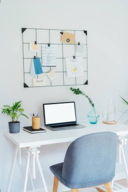 Modern Çağdaş iş yeri tasarımı. Bilgisayarlı beyaz masa, boş ekran, şifreli notlar ve planlar, yeşil santraller, ofis içi çalışma odasındaki ofis malzemeleri..