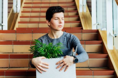 Kovulduktan sonra merdivenlerde yalnız başına oturan, ekonomik durgunluk ve ekonomik stres yüzünden işsiz kalmış, orta yaşlı, cinsiyet ayrımcılığı yapmayan endişeli bir kadın. Eşitlik ayrımcılığı