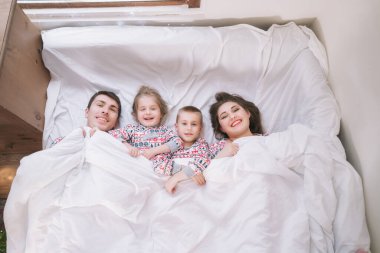 Noel arifesinde evlerinde yataklarında pijamalarıyla oynayan mutlu bir aile. Baba, anne, kız, oğul yatakta uzanıyor ve birlikte eğleniyorlar. Aile kış tatilini evde kutluyor.