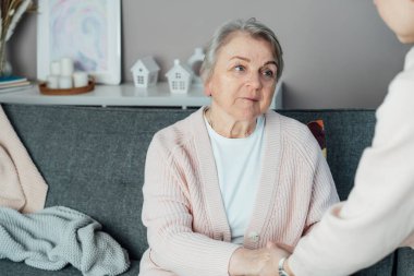 Yaşlı bir kadının elini sımsıkı tutan bir yüz bakıcısı yok. Yaşlı ebeveynler, büyük ebeveynler bakım, destek. Aile bakım evinde birlikte hassas bir anın tadını çıkarıyor. Nesiller boyu ilişki kavramı. Yaş bakımı