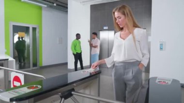 Ofis lobisi, ofis binasının girişinde bir geçiş sistemi, iş kadını turnikeden çıkıyor, uluslararası ofis..