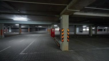 Yeraltı otoparkında yürümek, bir ofis binasının otoparkında düzgün bir kamera hareketi, beton sütunları ve duvarları olan boş bir alan..