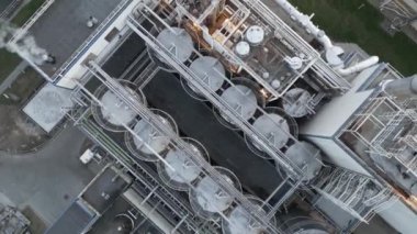 Endüstriyel manzara, büyük işleme fabrikası, yükseklikten çelik borular ve tankların görüntüsü, fabrikanın endüstriyel yapısı, borulardan gelen duman, kuadkopter çekim..