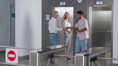 Ofis lobisi, ofis yöneticileri işe gider ve asansöre biner. Ofisin girişinde bir geçiş sistemi vardır. Adam turnikeden çıkar..