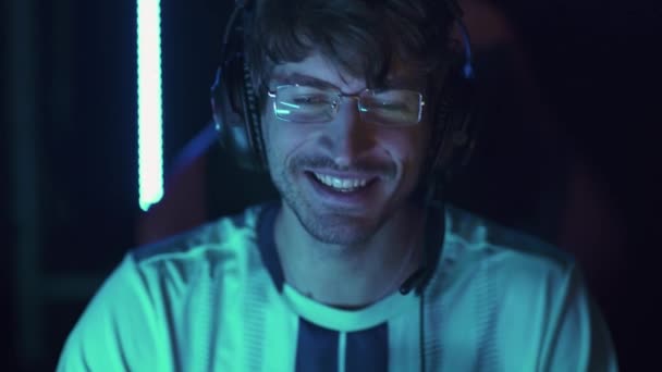 ハンドヘルド ヘッドフォンで男性ゲーマーの肖像画 ビデオゲーム 国際選手権でのサイバースポーツマン コミュニケーション 勝利の感情 — ストック動画