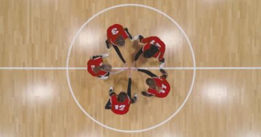 Basketbolculardan oluşan kırmızı takım birbirine beşlik çakıyor ve el kaldırıyor, maçtan önce moralleri yükseltiyor, uluslararası kadınlar basketbol şampiyonası, yüksekten bakıyor..