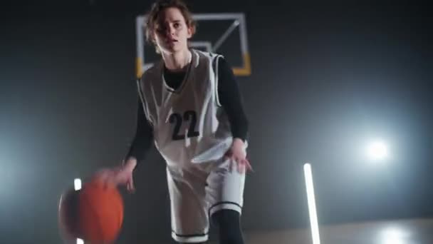 年轻女篮球运动员的形象在赛前把球打出地板热身 职业篮球运动员在室内操场上的表现 — 图库视频影像