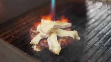 Yemek festivali, şef bir burger pişirir. Etli duble burger pişirme süreci. Kullan-at peynirli fırın..