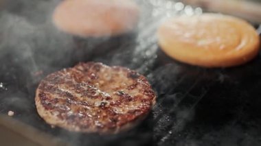 Yemek festivali, ızgarada hamburger pişirme süreci, et ve çörek ızgarada kızartılıyor, hamburger malzemeleri, 4K süper yavaş çekim..