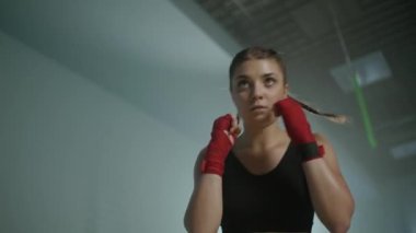 Kadın dövüşçü yumruklarını eğitiyor, boks salonunda antrenman yapıyor, kadın yumruk serisi hızlı, kadın gücü, 4k ağır çekim.