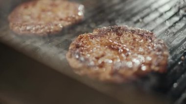 Sokak yemekleri, hamburger pişirme süreci, ızgarada kızartılmış et pirzolası, şef yemek festivalinde aşçılık yapıyor, 4k süper yavaş çekim..