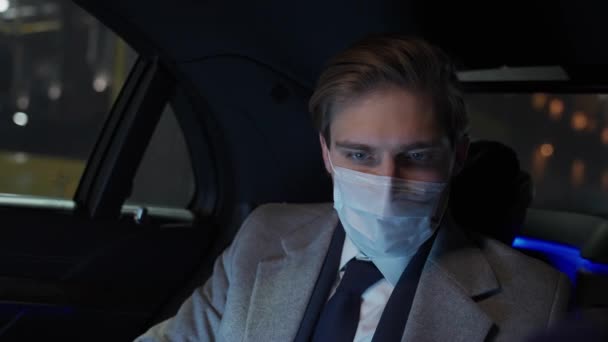 Fiatal Üzletember Öltönyben Egy Mozgó Autóban Dokumentumokkal Dolgozik Orvosi Maszkban — Stock videók