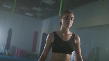 Yorgun bir kadın dövüşçünün portresi ellerini kaldırır, genç bayan boks salonundaki sıkı çalışmadan sonra iyileşir, zafer duyguları, kadın gücü, 4k ağır çekim.