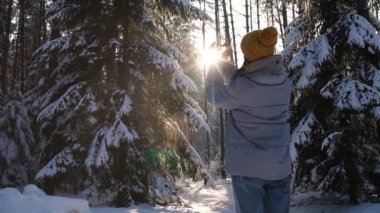 Kadın kış ormanlarında güneşin ışınlarıyla oynar, kadın kış yürüyüşü sırasında kışın eğlenir ve sembolü elleriyle gösterir..