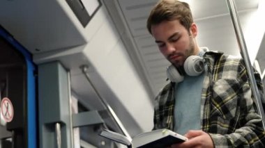 El bilgisayarı, genç adam metroya biniyor ve kitap okuyor, bir öğrenci üniversiteye okumaya gidiyor, sabah toplu taşımada, adam trenden iniyor..