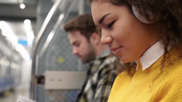 Студенти Їдуть Метро Слухають Музику Навушниками Використовують Смартфони Серфінг Інтернеті — стокове відео