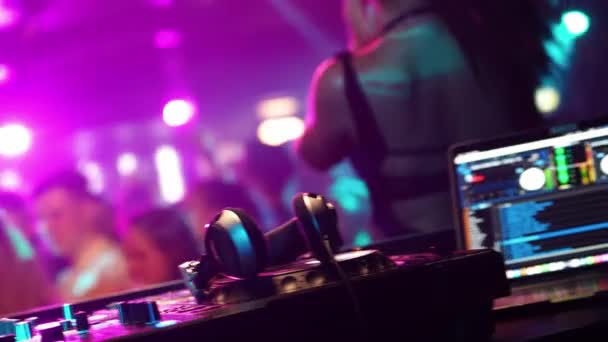 夜生活 Dj控制台的视图 Dj戴上耳机 年轻人在俱乐部的一个晚会上玩得很开心 五彩缤纷的灯光 音乐设备 — 图库视频影像