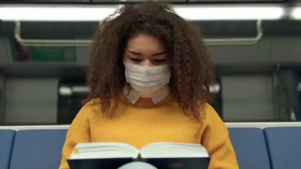 Vídeo Portátil Jovem Africana Máscara Médica Monta Metrô Livro Estudante — Vídeo de Stock