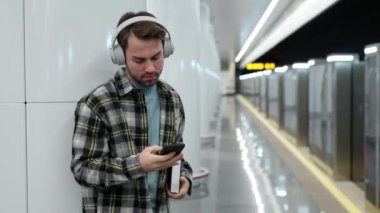 Genç adam metroda tren bekliyor, akıllı telefon kullanıyor ve kablosuz kulaklıkla müzik dinliyor, bir öğrenci üniversiteye okumaya gidiyor, toplu taşıma araçlarıyla..