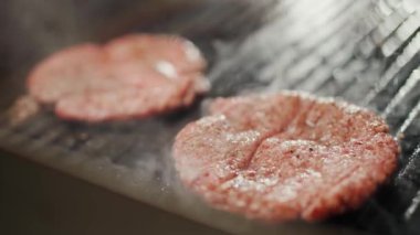 Sokak yemekleri, hamburger pişirme süreci, ızgarada kızartılmış et pirzolası, şef yemek festivalinde aşçılık yapıyor, 4k süper yavaş çekim..