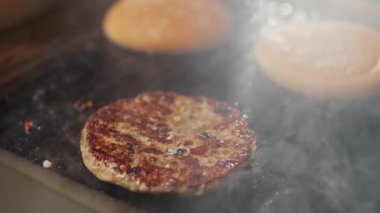 Yemek festivali, ızgarada hamburger pişirme süreci, et ve çörek ızgarada kızartılıyor, hamburger malzemeleri, 4K süper yavaş çekim..